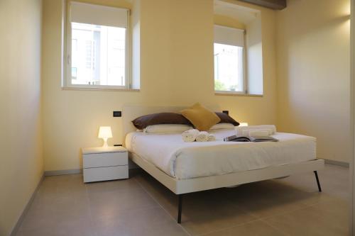 a bedroom with a white bed with two windows at Stelle di Verona - Selene in Verona