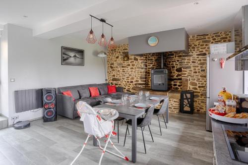 a dining room and living room with a table and chairs at Charme à la campagne avec spa in Saint-Senier-de-Beuvron