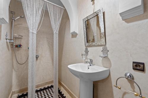 biała łazienka z umywalką i prysznicem w obiekcie Riad Marwa Marrakech w Marakeszu