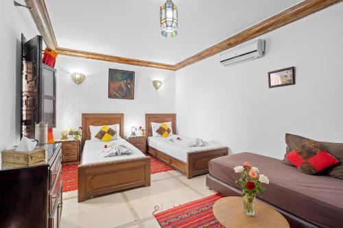 ein Wohnzimmer mit zwei Betten und einer Couch in der Unterkunft Riad Marwa Marrakech in Marrakesch