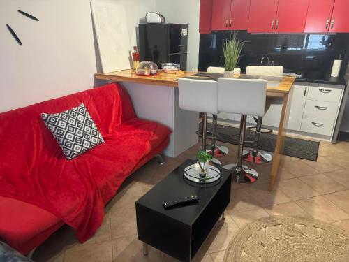 a living room with a red couch and a table at Luxury seafront house nearby Delphi in Kírra