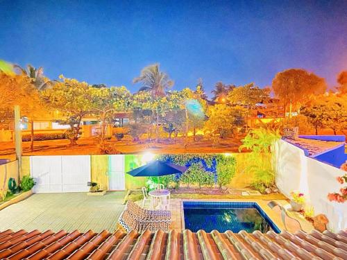 a house with a swimming pool and a patio at Casa bela in Lauro de Freitas