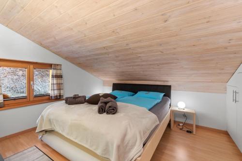 a bedroom with a large bed with blue pillows at Stilvolle 2.5 Zimmer Wohnung nähe Skigebiet in Savognin