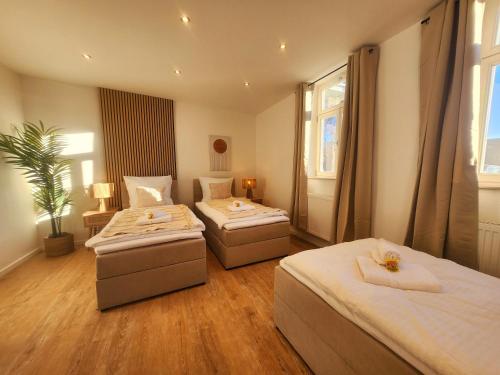 a bedroom with two beds and a potted plant at SiOUX stilvolle Designapartments am Ketschentor in Coburg