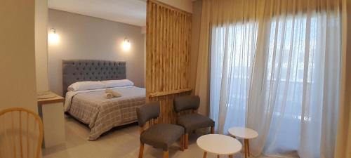 een slaapkamer met een bed en twee stoelen en een raam bij Complejo Cantal Porto in Salta