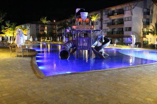 a fountain in the middle of a swimming pool at night at Refeições inclusa - Polinesia Resort - Porto de Galinhas - Apartamentos com somente 1 opção de Térreo com Piscina Privativa - Acesso ao Hotel Samoa in Porto De Galinhas