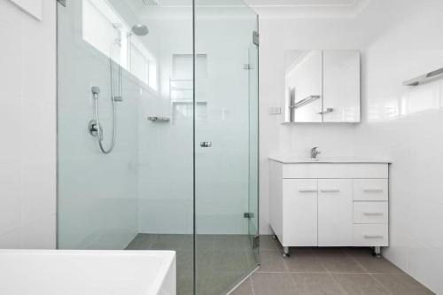 a white bathroom with a shower and a sink at Private Single Room - Centrally Located at Milperra - Shared Bathroom in East Hills