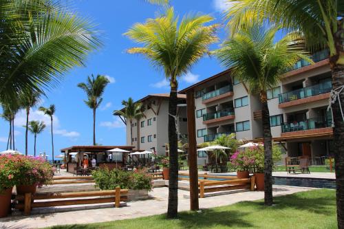 a hotel with palm trees in front of a building at Refeições inclusa - Polinesia Resort - Porto de Galinhas - Apartamentos com somente 1 opção de Térreo com Piscina Privativa - Acesso ao Hotel Samoa in Porto De Galinhas