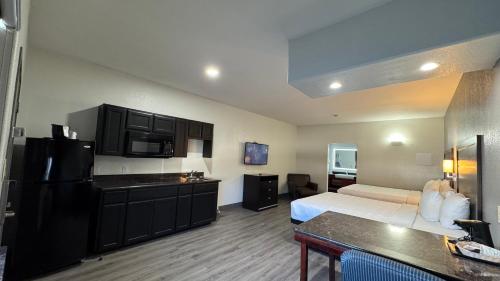 a hotel room with a bed and a kitchen at Sunbridge Inn & Suite Extended Stay in Jourdanton