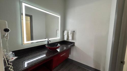 a bathroom with a sink with a large mirror at Sunbridge Inn & Suite Extended Stay in Jourdanton