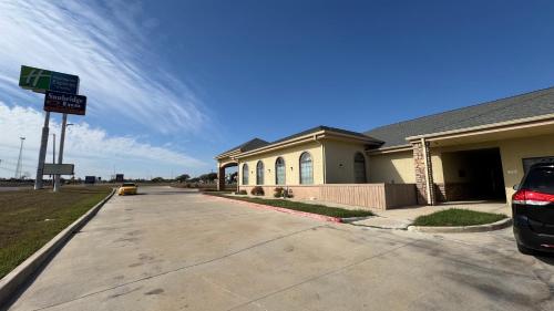 a house with a street sign in front of it at Sunbridge Inn & Suite Extended Stay in Jourdanton