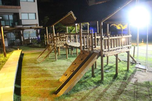 a group of wooden benches sitting in the grass at Refeições inclusa - Polinesia Resort - Porto de Galinhas - Apartamentos com somente 1 opção de Térreo com Piscina Privativa - Acesso ao Hotel Samoa in Porto De Galinhas
