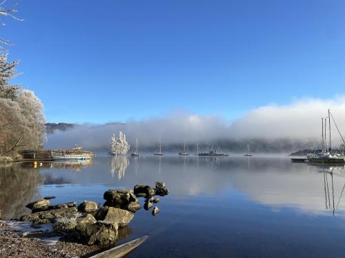a view of a lake with boats in the water at The Classrooms, Loch Ness Abbey - 142m2 Lifestyle & Heritage apartment - Pool & Spa - The Highland Club - Resort on lake shores in Fort Augustus