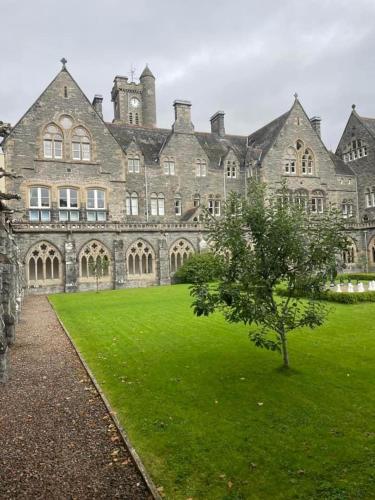a large building with a tree in front of it at The Classrooms, Loch Ness Abbey - 142m2 Lifestyle & Heritage apartment - Pool & Spa - The Highland Club - Resort on lake shores in Fort Augustus