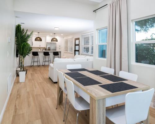 a dining room and living room with a table and chairs at Newly Built Coastal Home with Yard in San Diego