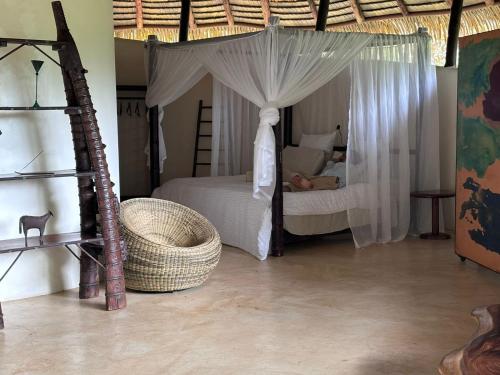 a bedroom with a bed with a canopy at Las Nubes Natural Energy Resort in Savegre