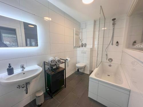 a bathroom with a sink and a tub and a toilet at Elegantes City-Apartment im Herzen von Bad Mergentheim in Bad Mergentheim