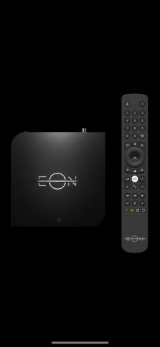 a remote control is sitting next to a television at Apartman Avenia in Novi Sad