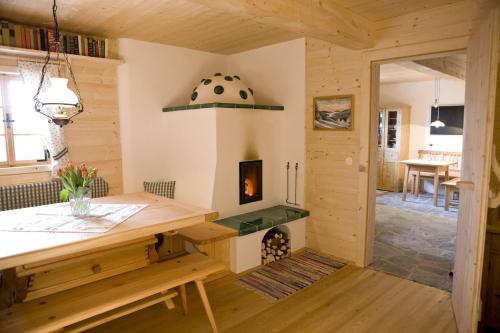 a room with a wooden table and a fireplace at Brandluckner Nesterl in Heilbrunn