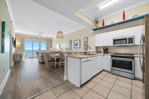 een keuken met witte kasten en een eetkamer bij Windemere Unit 1505 in Pensacola