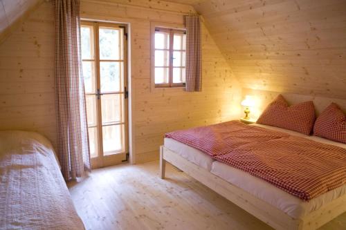 a bedroom with a bed in a log cabin at Brandluckner Nesterl in Heilbrunn