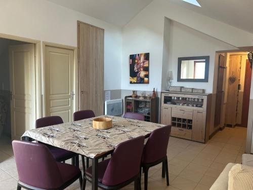 a dining room with a table and purple chairs at Valberg - Appartement 6 pers au pied des pistes in Valberg