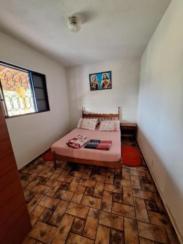 a small bedroom with a bed and a window at Mini Fazenda e Antiquário Manzolli in Monte Alegre do Sul