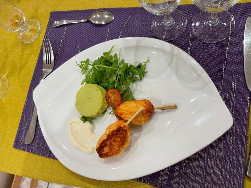 a white plate with food on a table at Merveilles88 in Rupt-sur-Moselle
