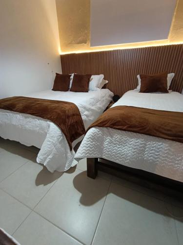 two beds sitting next to each other in a room at La Toscana Hostel in Villa de Leyva