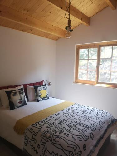 a bedroom with a bed with pillows and a window at Cabaninha de Cabana Maior in Cabana Maior