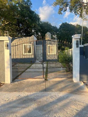 a gate in a park with a building at Casa Aurora in Pisté