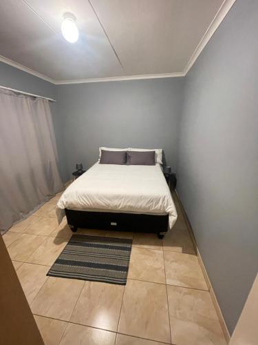 a bedroom with a bed and a rug on the floor at Hilo Family Accomodation in Swakopmund