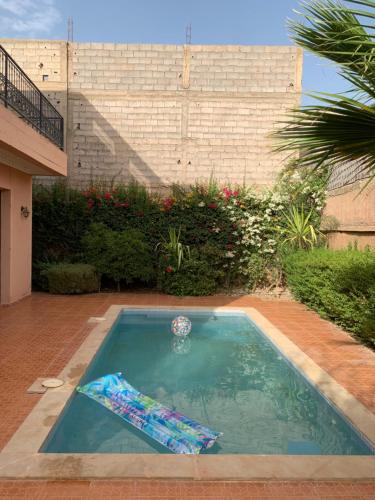 a small swimming pool in a yard with a building at Locanda House, Marrakech Sidi Ghiat in Marrakech