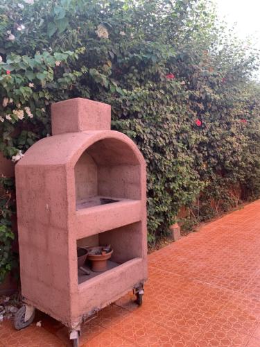 a brick oven sitting in front of a bush at Locanda House, Marrakech Sidi Ghiat in Marrakech