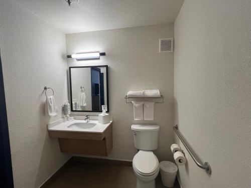 a bathroom with a toilet and a sink and a mirror at Spark by Hilton Phoenix-Glendale-Peoria in Glendale