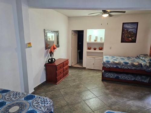 a bedroom with two beds and a dresser and a mirror at Casablanca Bonfil #1 in Acapulco