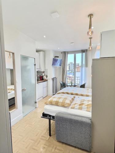 une grande chambre avec un lit et une cuisine dans l'établissement Studio Parc-Expo Vanves Paris 15ième, à Vanves