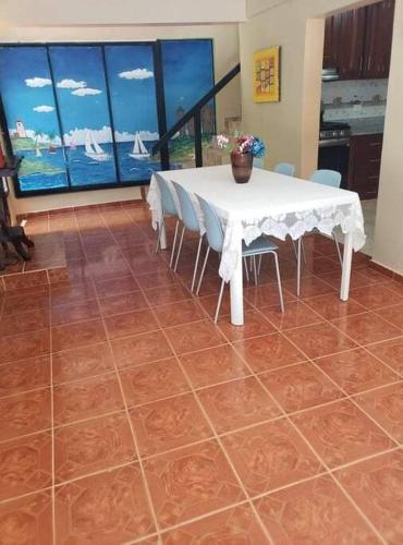 a dining room with a white table and chairs at Home away from Home in La Villa Isabela in La Isabela