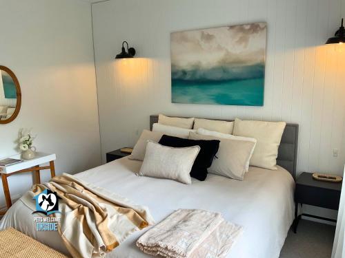 a bedroom with a large white bed with pillows at Saltwater Sunsets Seaside Haven with Ocean Views in Victor Harbor