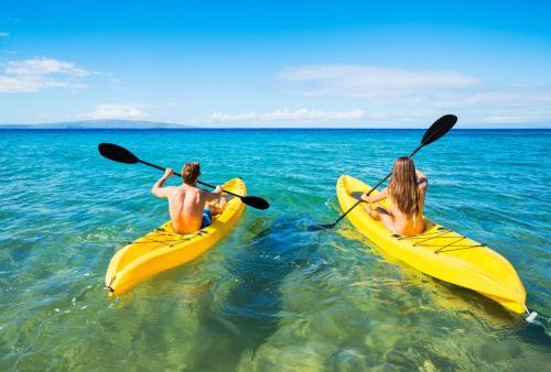 two people in yellow kayaks in the water at Kihei Alii Kai A207 · KAK A207 Renovated Kihei Condo Near Beach in Kihei