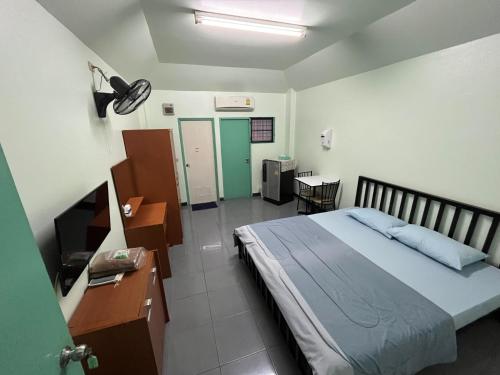 a bedroom with a bed and a desk and a desk at ธรรศิกา อพาร์ทเม้นท์ in Kanchanaburi City