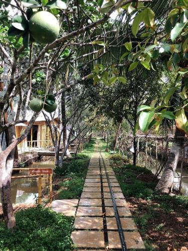 a path in a garden with trees at Hide Away Bungalows in Ben Tre City in Ben Tre