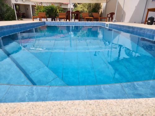 a swimming pool with blue water in a house at La brise Du Cap in Cap Skirring