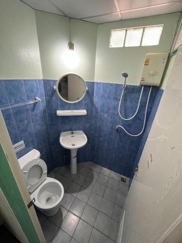 a bathroom with a toilet and a sink and a shower at ธรรศิกา อพาร์ทเม้นท์ in Kanchanaburi City