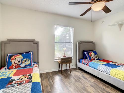 a bedroom with two beds and a ceiling fan at Private 4BR villa with Screened in pool large yard in Kissimmee