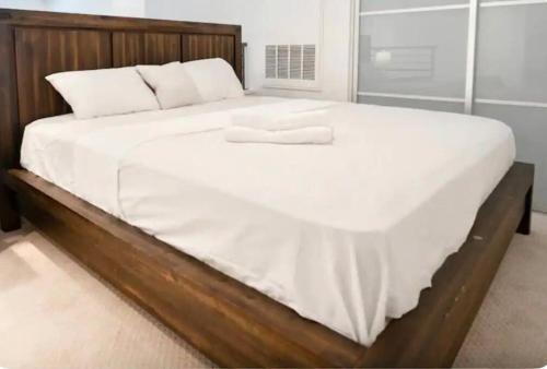 a large bed with white sheets and pillows on it at Luxury Penthouse Loft w POOL GYM AMERICANA in Glendale