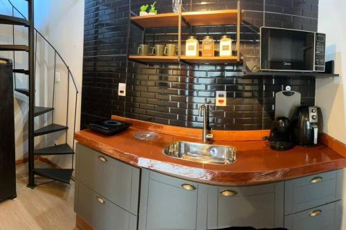 una cucina con un lavello e un muro di mattoni di A Jóia do Cassino a Rio Grande