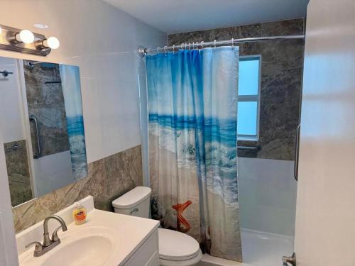 Un baño con ducha, inodoro y lavabo. en Seashell 7, en Boynton Beach