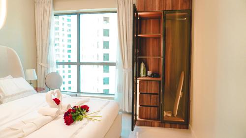 a bedroom with a white bed with a bouquet of flowers on it at USMANS 3 Bedroom Apartment all Rooms Sea View Direct Beach Access Daily HOUSEKEEPING JBR in Dubai