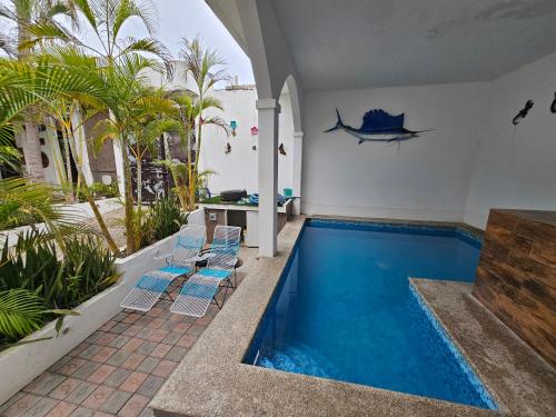 a pool in a house with chairs and a table at Casablanca Bonfil #1 in Acapulco
